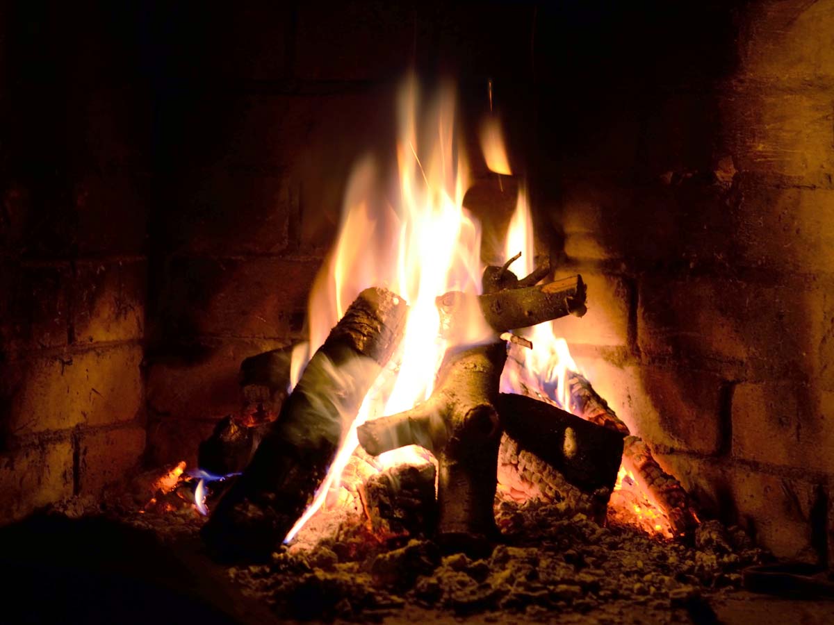 roaring fire in dark fireplace