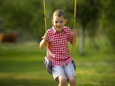 boy swinging in backyard