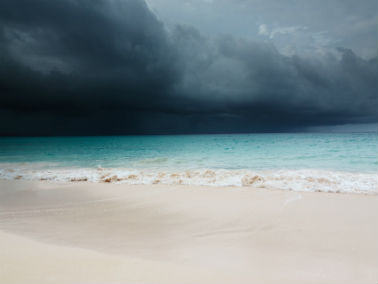 storm brewing in background on tropical beach