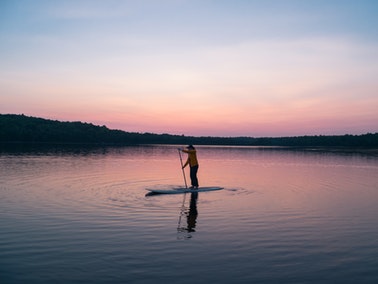 person on a paddleboard in the evening