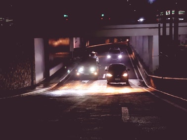 cars with headlights shining on road
