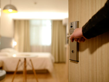 person opening hotel room door