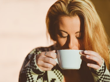 woman drinking out of a mug