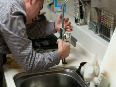 man trying to fix faucet