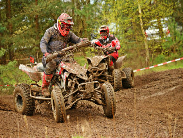 Two atv riders dressed in protective gear on their atvs