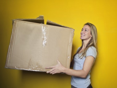 Woman carrying a cardboard box and planning to move