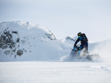 person riding snowmobile in winter