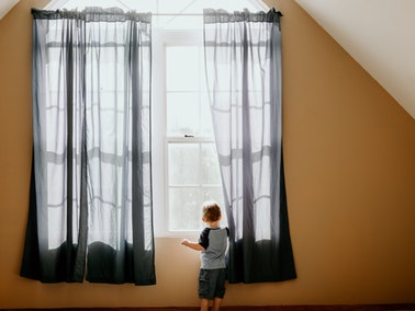 boy standing in front of window