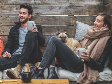 young couple sitting inside with their dog